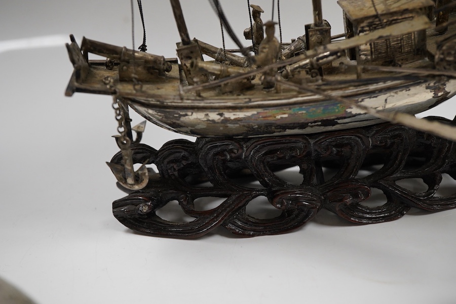 A pair of modern silver fighting cocks, import marks for Sheffield, Assay Office, Sheffield, 1977, height 68mm, together with a Chinese white metal miniature model of a ship, on a carved hardwood base, overall height 20.